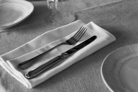 restaurant cutlery, knife and fork on a table with napkinの写真素材