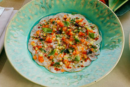 octopus carpaccio in a green plate with lemon olive dressingの写真素材