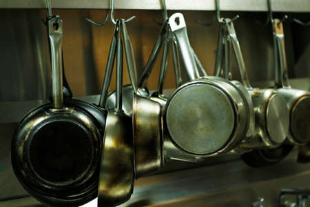 kitchen utensils, pans and pots hanging with hooksの写真素材