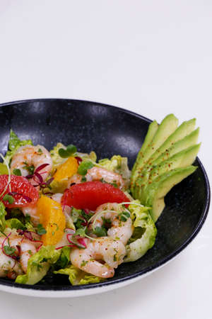 salad with avocado and shrimps in bowl, top view, copy space, black backgroundの写真素材