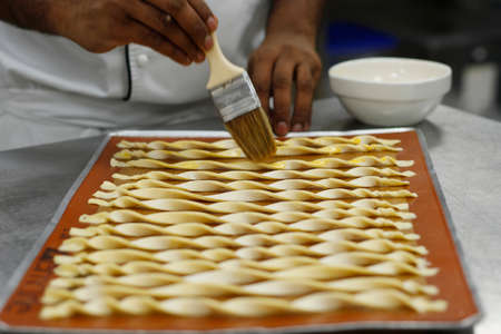 chef making lavash bread sticks in bakery kitchenの写真素材