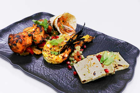 tandoori platter with chicken tikka, grilled prawns, and paneer along with dal makhani, wheat bread and chutneysの写真素材