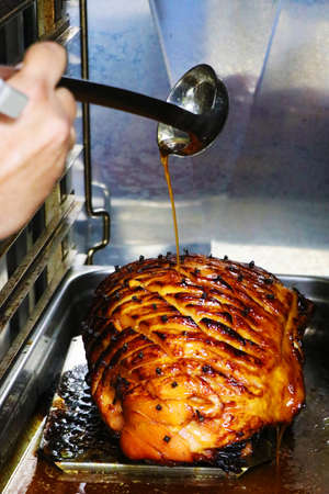 glazed gammon ham with traditional herbs and spicesin a roasting tray,Cooked meat for festive seasonsの写真素材