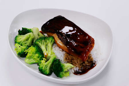 teriyaki salmon with steamed broccoli and jasmine rice in a bowlの写真素材