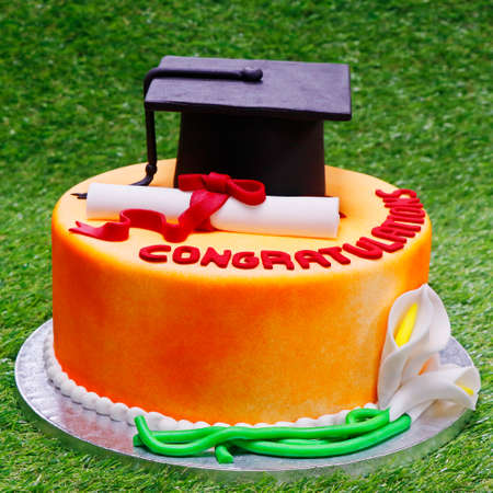 graduation cake with green grass background isolatedの写真素材
