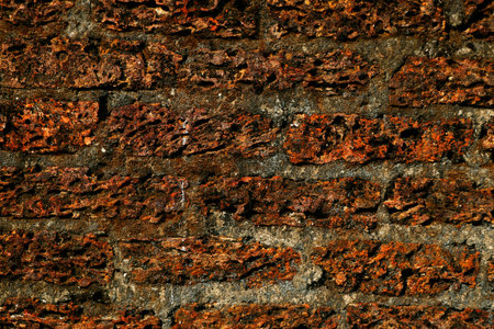 Old laterite wall laterite texture background,Pattern decorative uneven cracked real stone wall surface with cementの写真素材