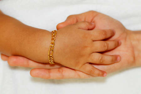 mother holding a baby's hand, love momentの写真素材