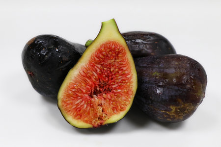 Ripe juicy raw fig fruit and cut slice and half with pulp and seeds isolated on white backgroundの写真素材