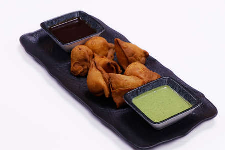 Indian snack samosa plater with mint and tamarind sauce