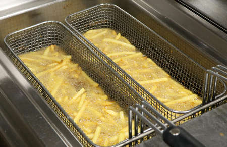 potato chicps frying in a deep fryerの写真素材