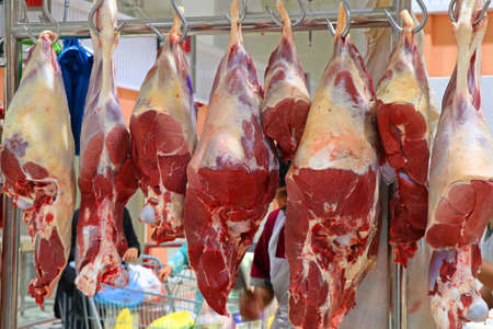 butcher shop with hanged fresh beef meatsの写真素材