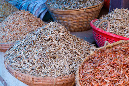 different variety of dry fishes stored in a basket for sell in a market stallの写真素材