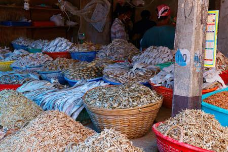 Kochi, Kerala, India -March 6, 2021 different variety of dry fishes stored in a basket for sell in a market stallのeditorial素材