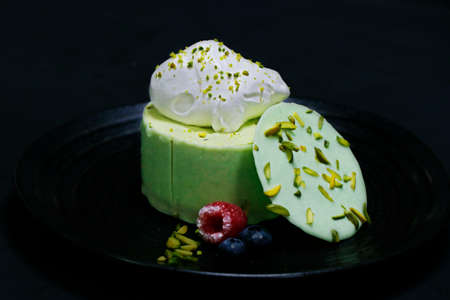 pistachio flavored mousse cake, decorated with berries and fresh creamの写真素材