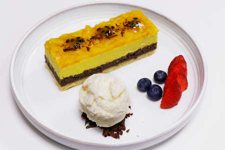 mango mousse cake with vanilla ice cream and berriesの写真素材