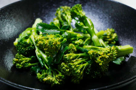 steam broccoli or broccolini with black background in close up, healthy food concept, vegetarian dietの写真素材