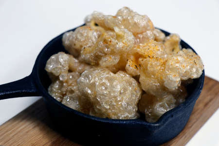 sun dried and deep fat fryer crispy pork skin known as chicharon in a serving dish, asian delicacy...