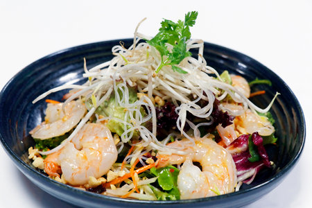 thai style spicy shrimp salad with crunchy vegetables, peanuts and bean sprouts on white backgroundの写真素材