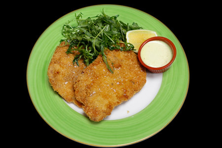 breaded deep fried pork tenderloin known as schnitzel or escalope with sour cream and rocket lettuceの素材 [FY310207316480]