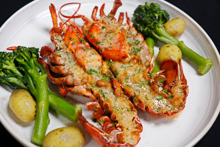 canadian maine lobster thermidor dish with broccoli and baby potato, black backgroundの写真素材