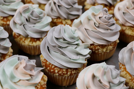 rainbow frosted vanilla flavored cupcake or muffin with sprinklesの写真素材