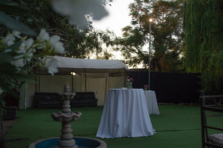 wedding ceremony with chairs and tables in the garden at sunsetの写真素材