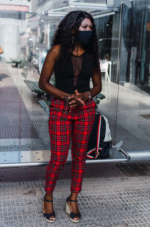 Girl black waiting at the bus stopの写真素材