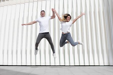Two teenagers in love jump for joy. fun and laughs on a bright dayの写真素材