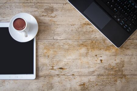 still life of communication and business elements a computer a tablet pc and a coffee perched on a wooden table. lifestyleの写真素材
