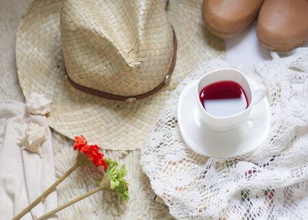 Holiday still life. own summer elements. Cup of tea, cowboy boots, hat, tablecloths and some flowersの写真素材