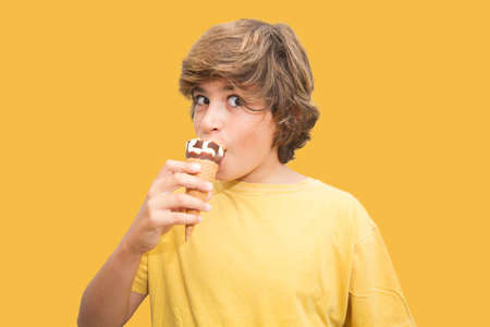 A boy holding ice cream while wearing a mask