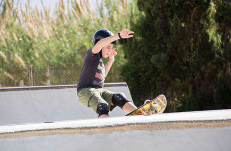 Teenage boy in skateboard park against blue skyの写真素材