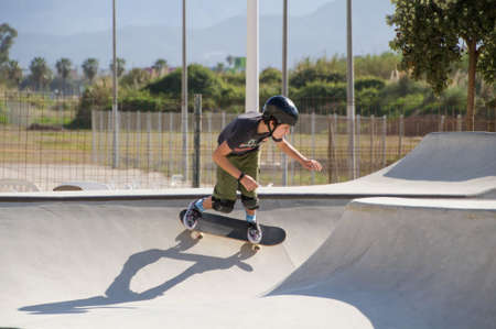 Teenage boy in skateboard park against blue skyの写真素材