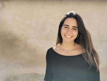 Portrait of a beautiful brunette Spanish girl with long brown hair smilingの写真素材