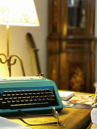 Warm and cozy artist's writing corner with typewriter and glassesの写真素材