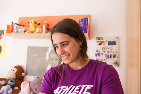 An attractive young girl looking to the side, smiling in the house.の写真素材