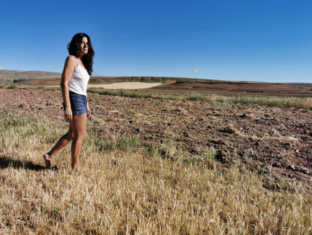 Beautiful middle-aged brunette woman walking in the countryside barefoot. copy-spaceの写真素材