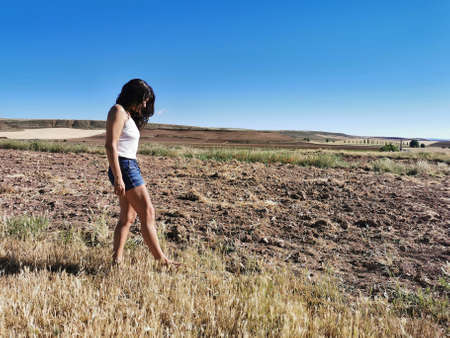 Beautiful middle-aged brunette woman walking in the countryside barefoot. copy-spaceの写真素材