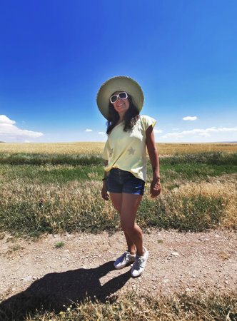 Attractive middle-aged happy woman in a hat enjoying the countryside and holidaysの写真素材