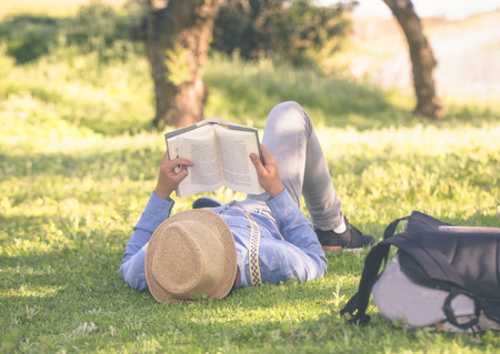 Young teenager reads placidly on the grassの写真素材