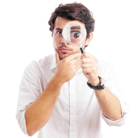 young man looking through magnifying glassの写真素材