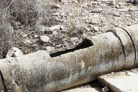 Aged and cracked concrete pipe for watering.の写真素材