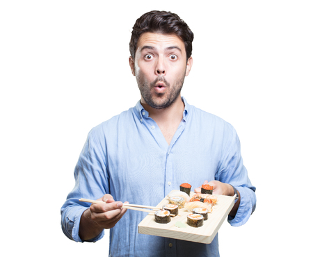 Young man eating sushi on white backgroundの写真素材