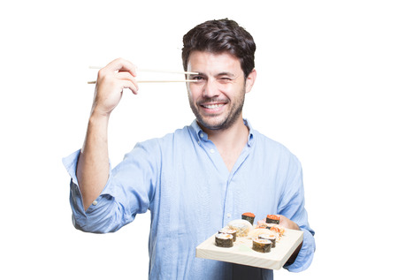 Young man eating sushi on white backgroundの写真素材