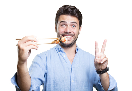 Young man eating sushi on white backgroundの写真素材