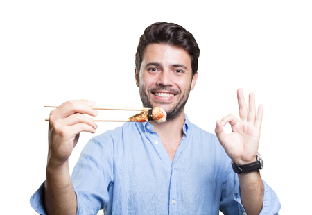 Young man eating sushi on white backgroundの写真素材
