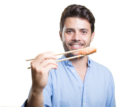 Young man eating sushi on white backgroundの写真素材