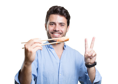 Young man eating sushi on white backgroundの写真素材