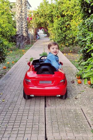 Baby driving a red carの写真素材