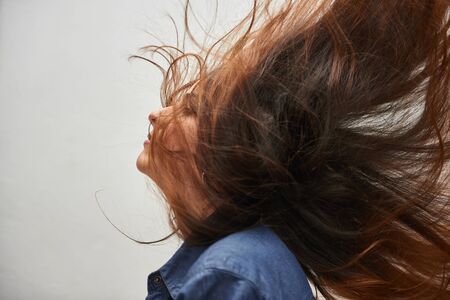Beautiful photo of a model with loose hair rocked by the windの写真素材